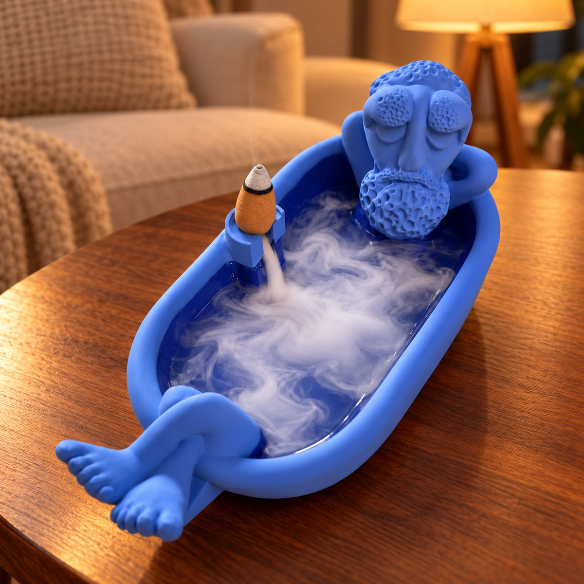 Blue bathing grandpa backflow incense burner with smoke in a warm living-room setting. Incense cones not included.