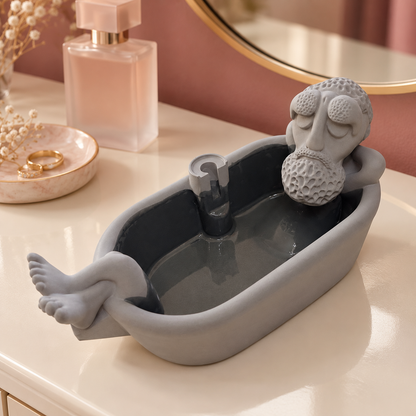 Gray bathtub-shaped grandpa incense burner on a vanity, empty cone holder visible.